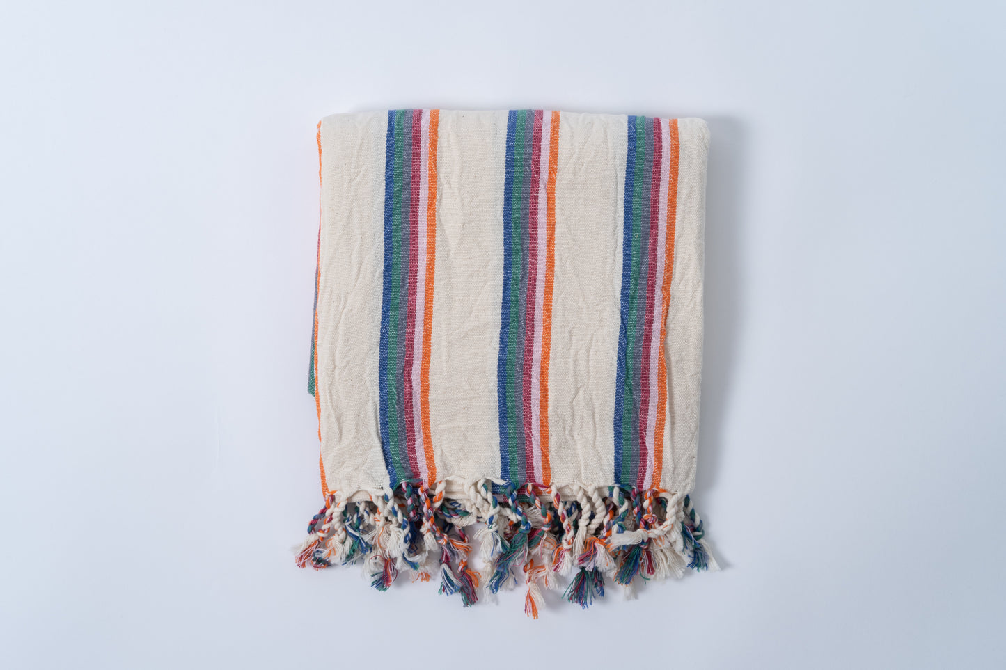 Striped towel with colorful border on a light gray background