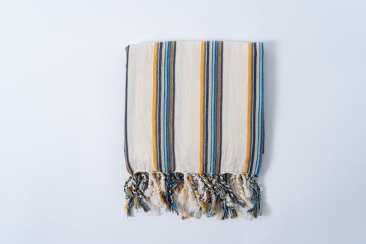 Striped towel with tassels on a light gray background