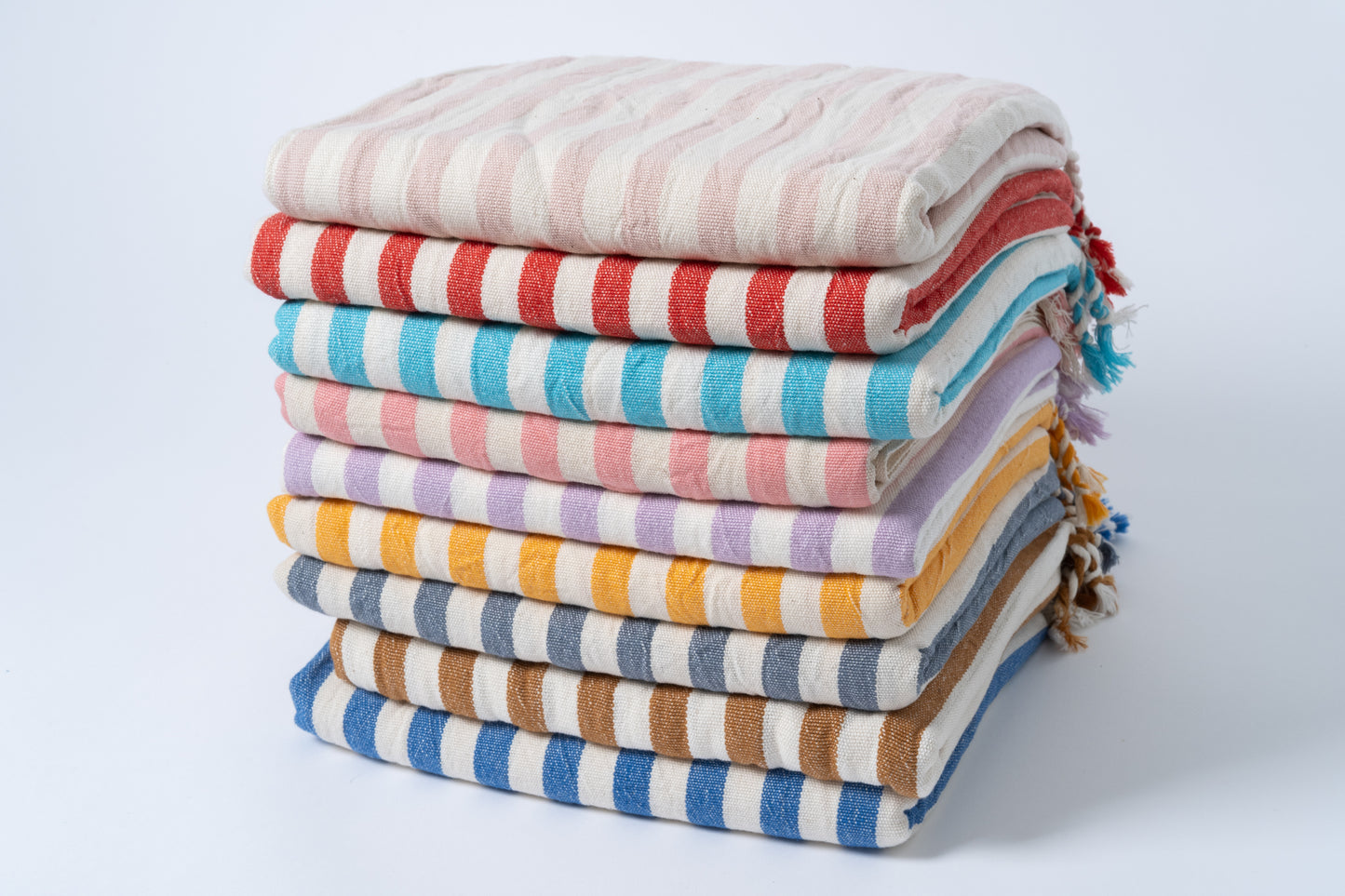 Stack of colorful striped towels on a light gray background