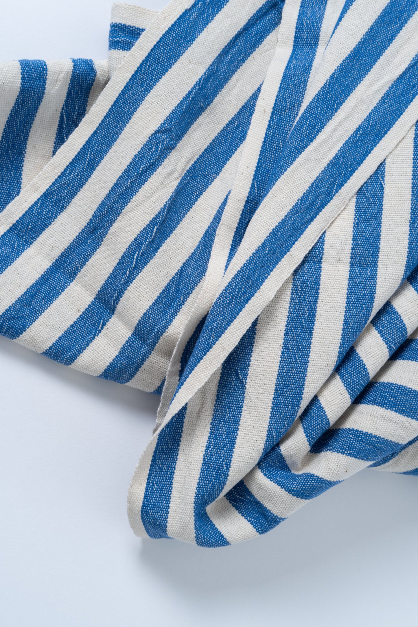 Blue and white striped fabric on a light gray background