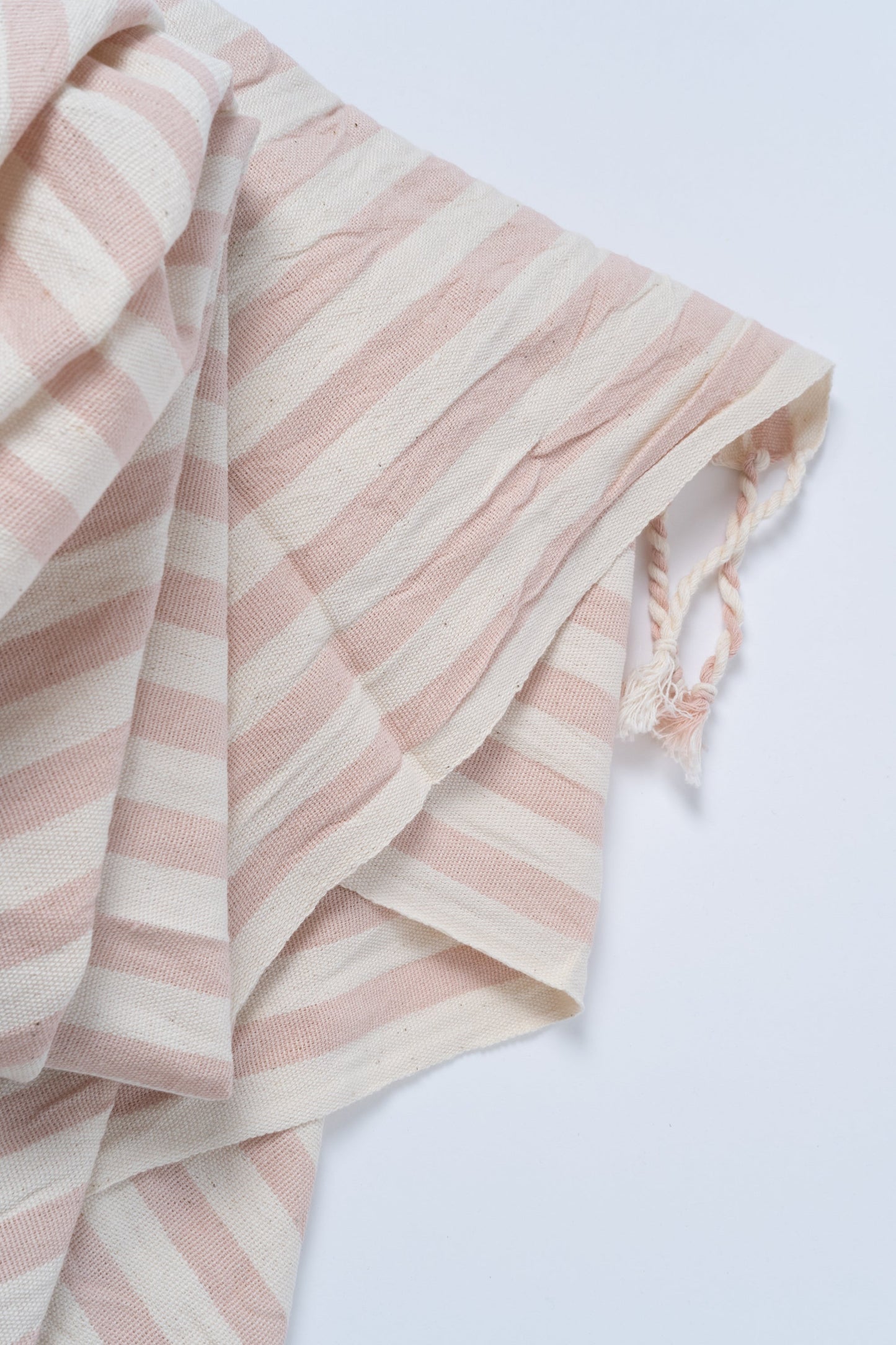 Pink and white striped fabric on a light gray background