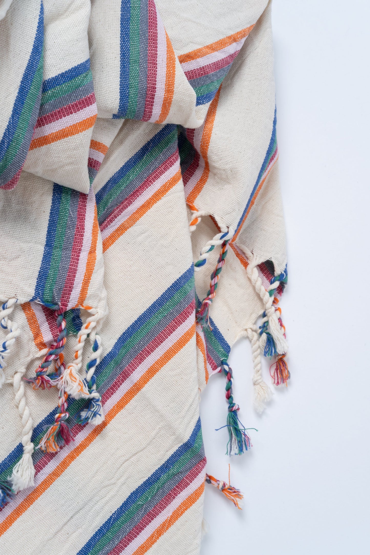 Colorful striped fabric with tassels on a white background