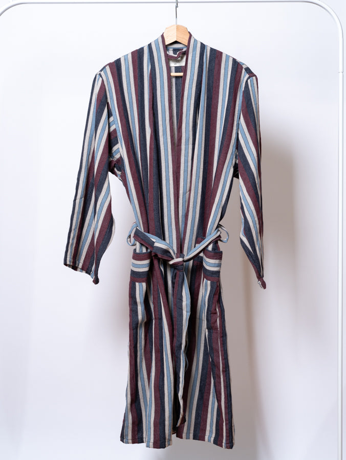 Striped robe on a hanger against a white background