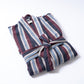 Folded striped robe on a white background