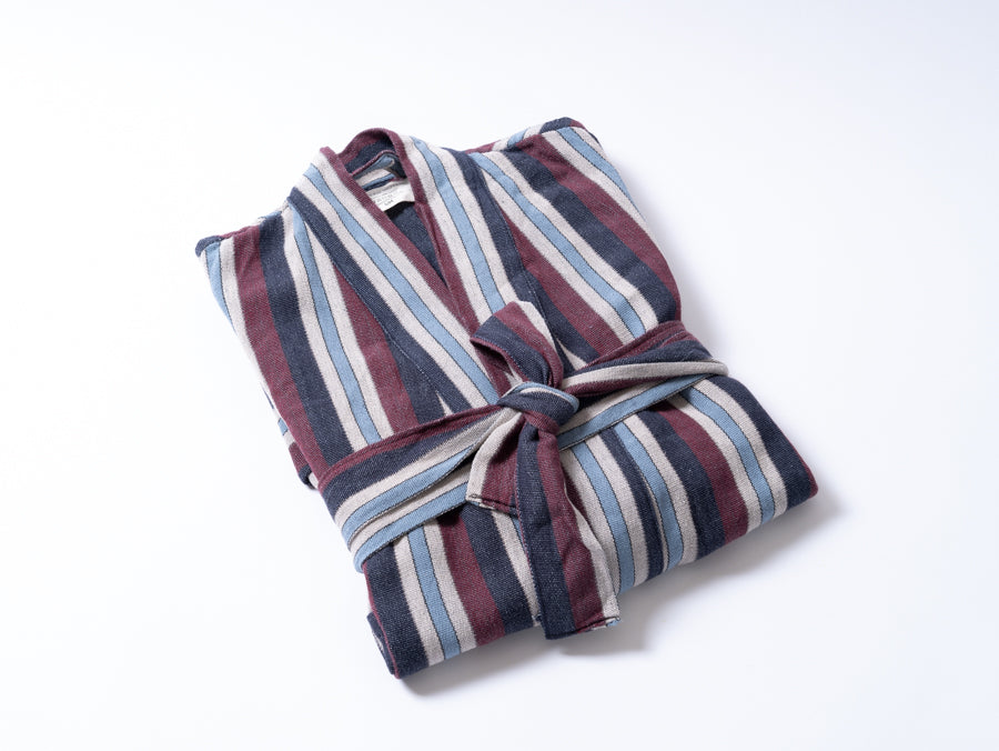 Folded striped robe on a white background