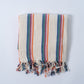 Striped towel with colorful border on a light gray background