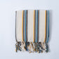 Striped towel with tassels on a light gray background