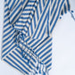 Blue and white striped towel with tassels on a light gray background