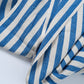 Blue and white striped fabric on a light gray background