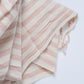Pink and white striped fabric on a light gray background