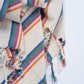 Colorful striped fabric with tassels on a white background