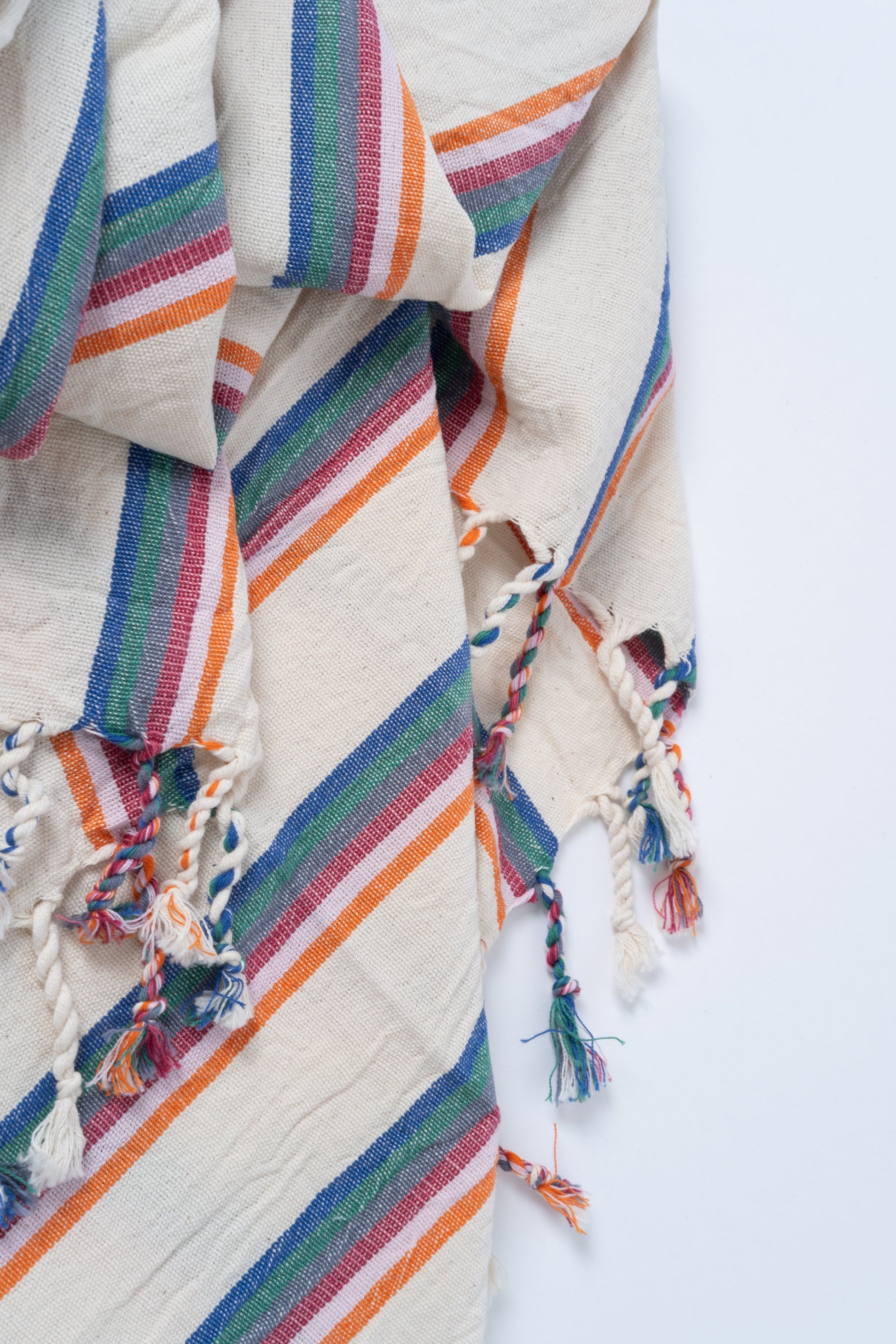 Colorful striped fabric with tassels on a white background