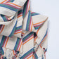 Colorful striped fabric with embroidered patterns on a white background