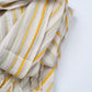 Striped fabric with yellow and beige lines on a light gray background