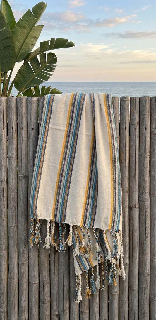 Striped towel hanging on a wooden fence with ocean view