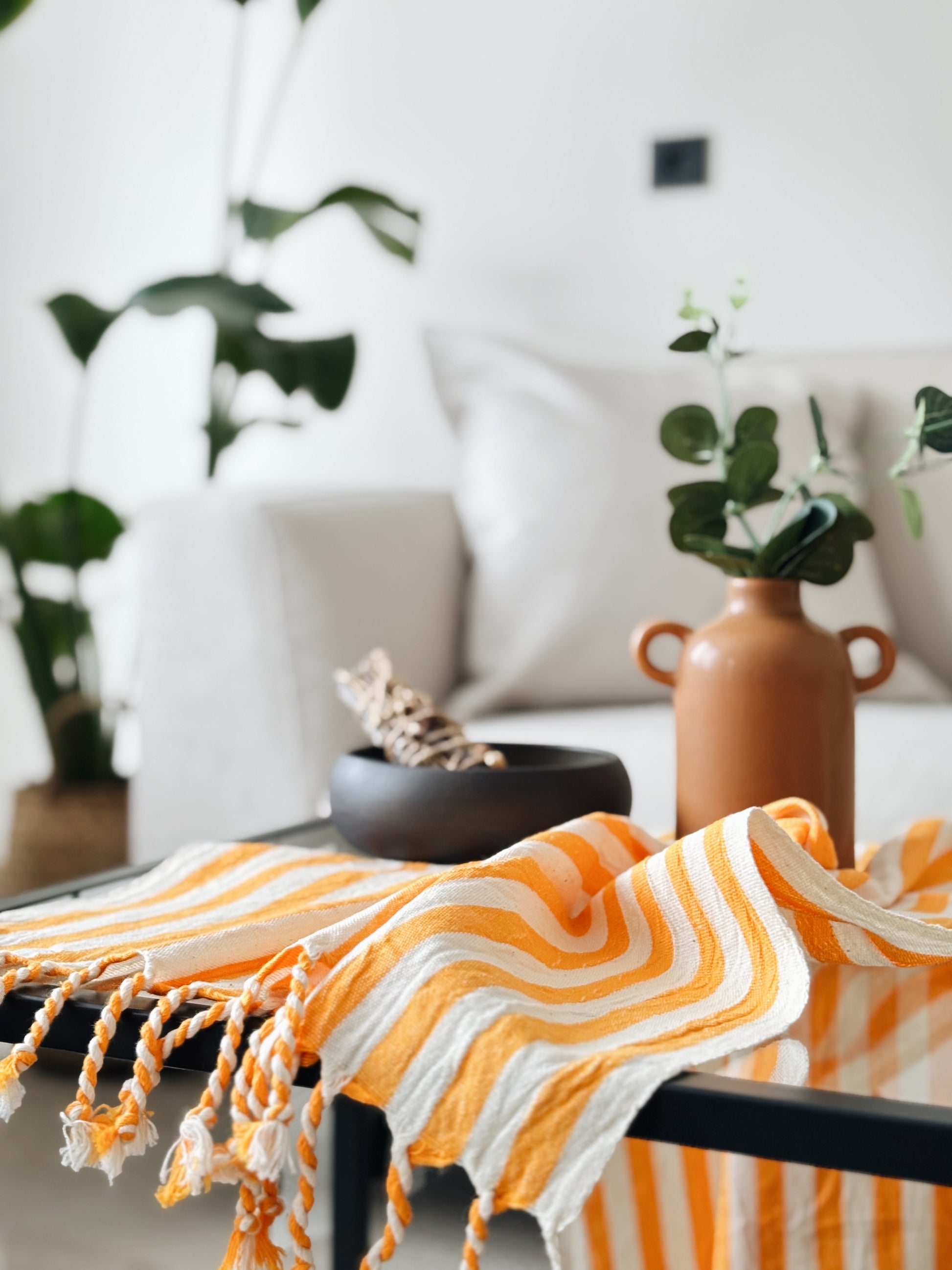 Orange and white striped towel on a table with a blurred indoor setting